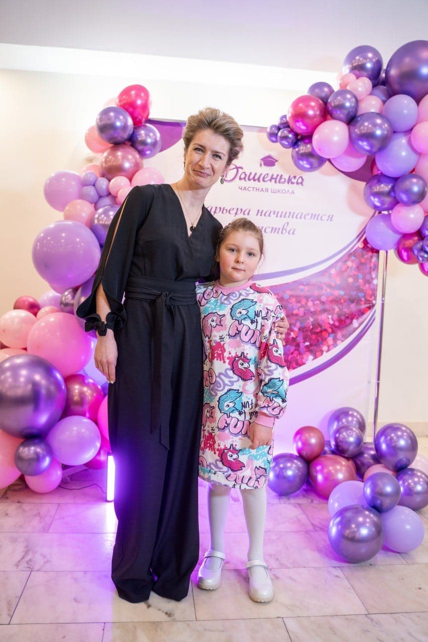 Девочка со взрослым у праздничной фотозоны
