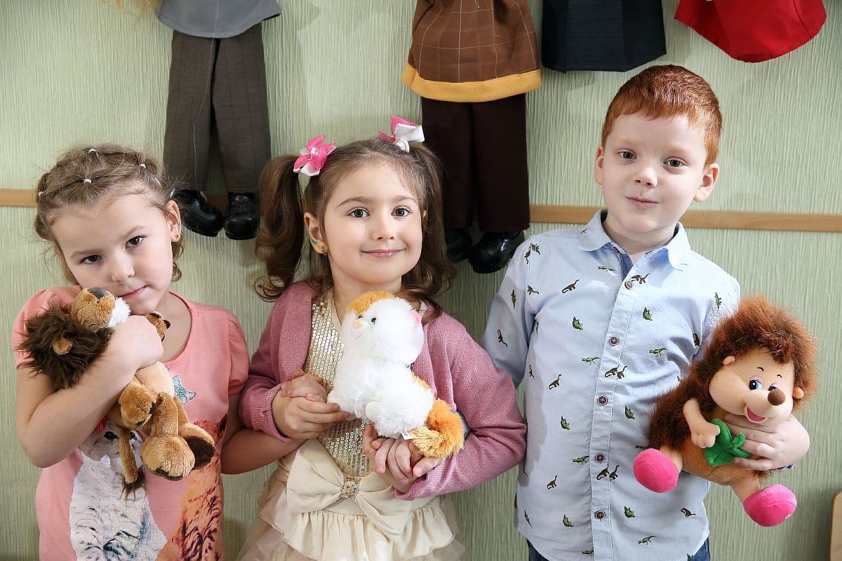 Малыши с мягкими игрушками в классе