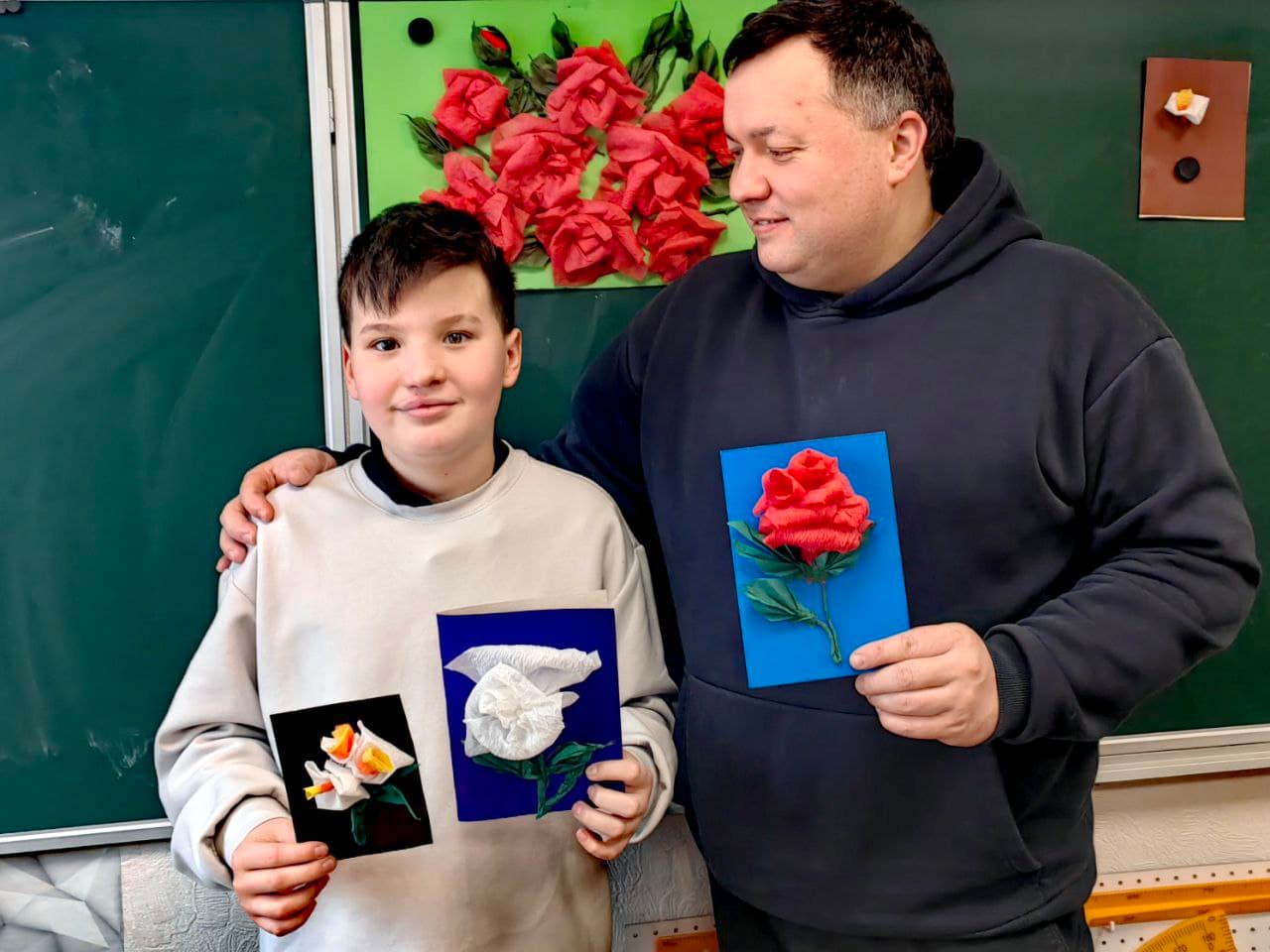 Ученик и папа показывают работы с выставки