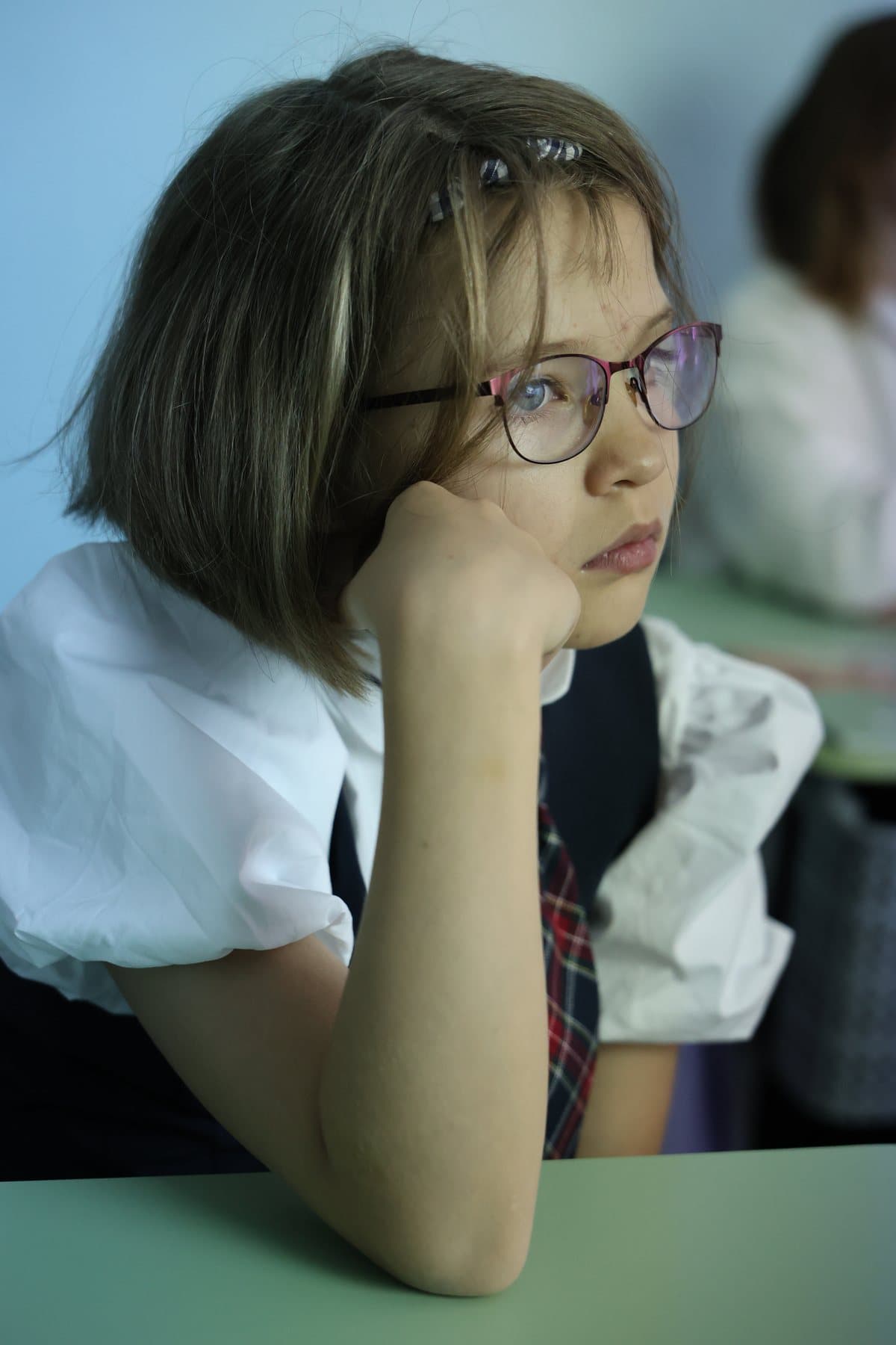 Ученица в очках задумалась на уроке