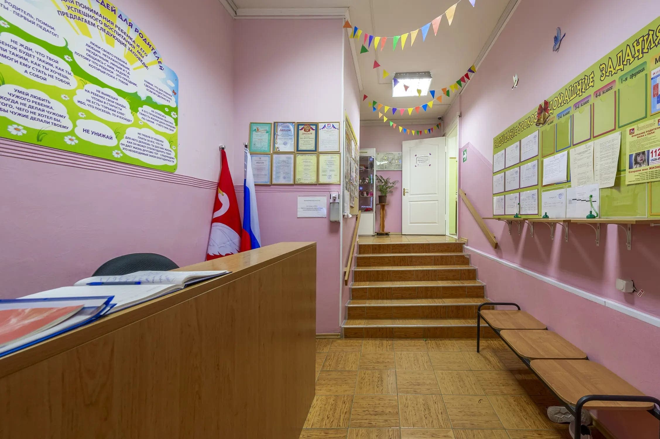 Холл у входа: стойка администратора и лестница